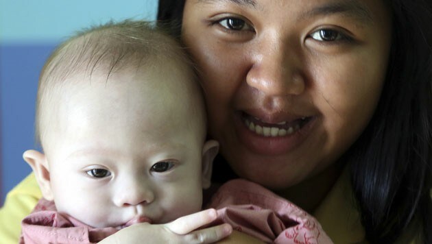 Baby Gammy mit seiner thailändischen Leihmutter, der erst 21-jährigen Pattaramon Chanbua (Bild: AP)