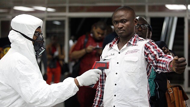 Flugpassagiere werden auf dem Flughafen von Lagos auf eine erhöhte Temperatur überprüft. (Bild: AP)