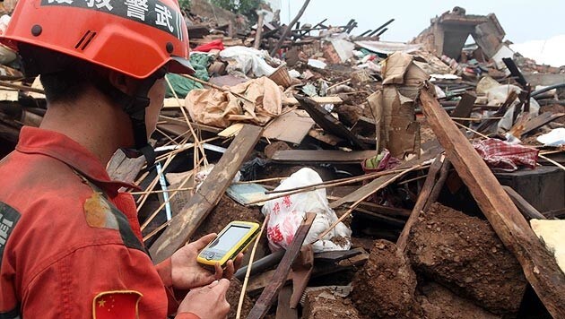 Retter auf der Suche nach Überlebenden unter den Trümmern (Bild: AP)
