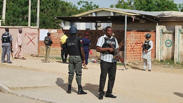 Polizisten sichern den Tatort nach dem Selbstmordanschlag in Kano. (Bild: AP)