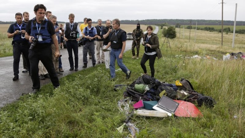 OSZE-Ermittler nahe der Absturzstelle. Der Zugang zum Trümmerfeld wurde ihnen teilweise verwehrt. (Bild: AP)