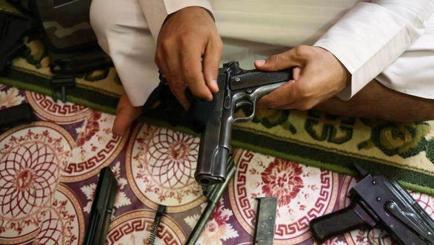 Ein Waffenhändler in Bagdad zeigt sein Angebot. (Bild: AP (Symbolbild))